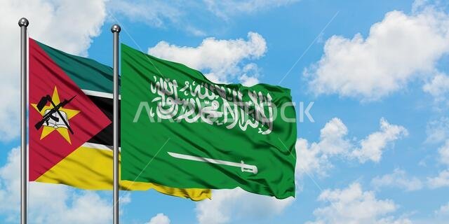 يرفرف علما موزمبيق والسعودية معاً في مهب الريح أمام سماء زرقاء صافية تتخللها غيوم بيضاء. مفهوم الدبلوماسية، العلاقات الدولية.