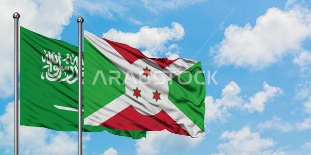 يرفرف علم المملكة العربية السعودية وعلم بوروندي معاً في مهب الريح أمام سماء زرقاء صافية تتخللها غيوم بيضاء. مفهوم الدبلوماسية، العلاقات الدولية.