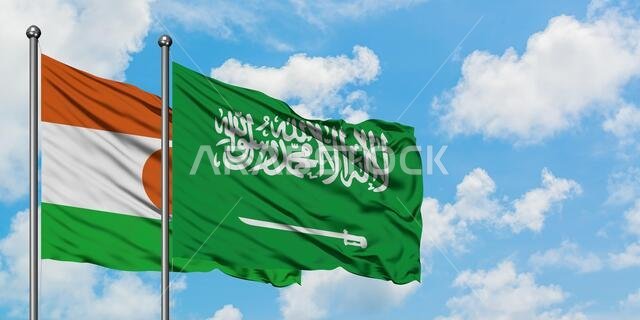 Niger and Saudi Arabia flag waving in the wind against white cloudy blue sky together. Diplomacy concept, international relations.