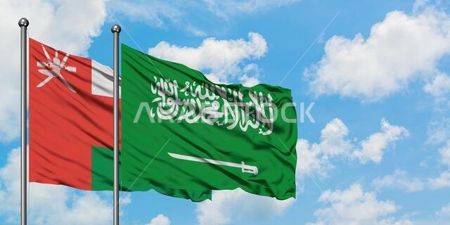 يرفرف علم عُمان وعلم المملكة العربية السعودية معاً في مهب الريح أمام سماء زرقاء صافية تتخللها غيوم بيضاء. مفهوم الدبلوماسية، العلاقات الدولية. يرفرف علم عُمان وعلم المملكة العربية السعودية معاً في مهب الريح أمام سماء زرقاء صافية تتخللها غيوم بيضاء. مفهوم الدبلوماسية، العلاقات الدولية.