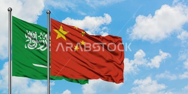 Saudi Arabia and China flag waving in the wind against white cloudy blue sky together. Diplomacy concept, international relations.