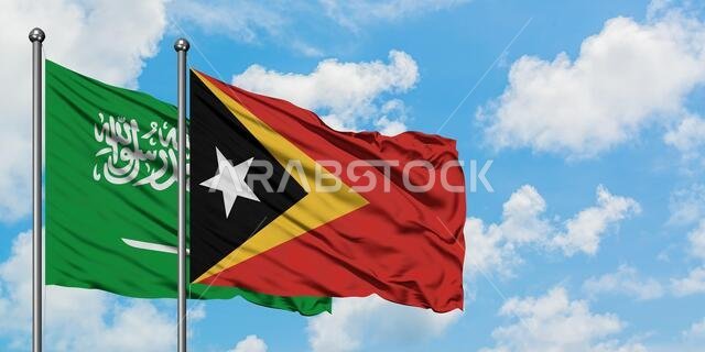 Saudi Arabia and East Timor flag waving in the wind against white cloudy blue sky together. Diplomacy concept, international relations.