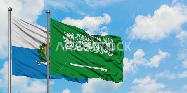 San Marino and Saudi Arabia flag waving in the wind against white cloudy blue sky together. Diplomacy concept, international relations.