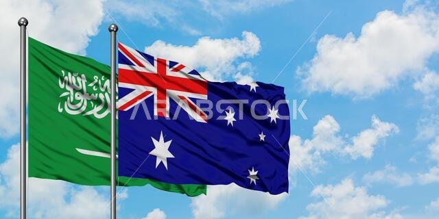 Saudi Arabia and Australia flag waving in the wind against white cloudy blue sky together. Diplomacy concept, international relations.