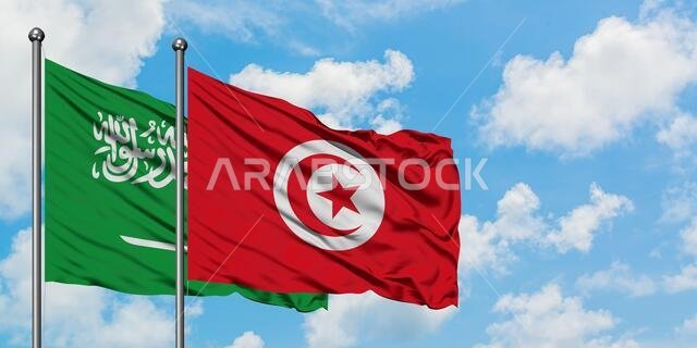 يرفرف علم المملكة العربية السعودية وعلم تونس معاً في مهب الريح أمام سماء زرقاء صافية تتخللها غيوم بيضاء. مفهوم الدبلوماسية، العلاقات الدولية.