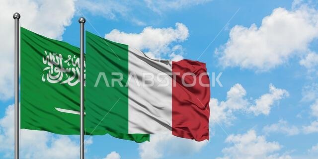 Saudi Arabia and Italy flag waving in the wind against white cloudy blue sky together. Diplomacy concept, international relations.