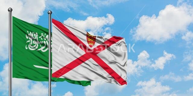 يرفرف علم المملكة العربية السعودية وعلم جيرسي معاً في مهب الريح أمام سماء زرقاء صافية تتلألأ بالغيوم البيضاء. مفهوم الدبلوماسية، العلاقات الدولية.