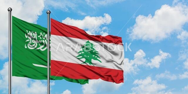 يرفرف علم المملكة العربية السعودية وعلم لبنان معاً في مهب الريح أمام سماء زرقاء صافية تتخللها غيوم بيضاء. مفهوم الدبلوماسية، العلاقات الدولية.