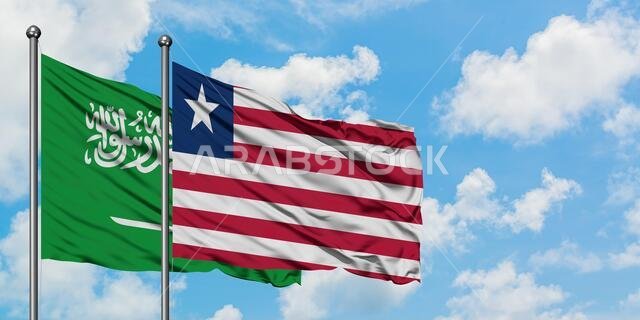 يرفرف علم المملكة العربية السعودية وعلم ليبيريا معاً في مهب الريح أمام سماء زرقاء صافية تتلألأ فيها الغيوم البيضاء. مفهوم الدبلوماسية، العلاقات الدولية.