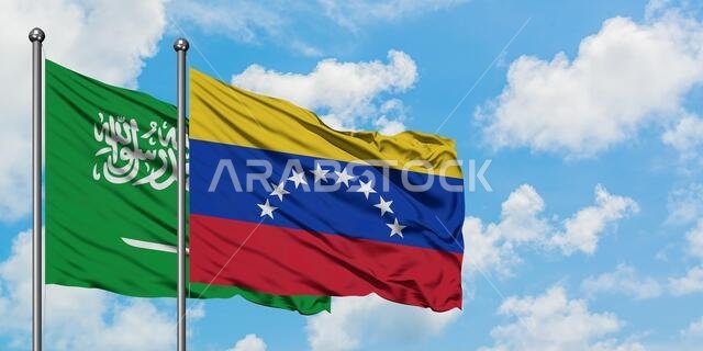 Saudi Arabia and Venezuela flag waving in the wind against white cloudy blue sky together. Diplomacy concept, international relations.