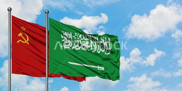 يرفرف علم الاتحاد السوفيتي وعلم المملكة العربية السعودية معاً في مهب الريح أمام سماء زرقاء صافية تتلألأ بالغيوم البيضاء. مفهوم دبلوماسي، علاقات دولية.