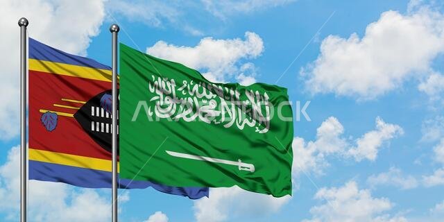 يرفرف علم سوازيلاند وعلم المملكة العربية السعودية معاً في مهب الريح أمام سماء زرقاء صافية تتلألأ فيها الغيوم البيضاء. مفهوم الدبلوماسية، العلاقات الدولية.