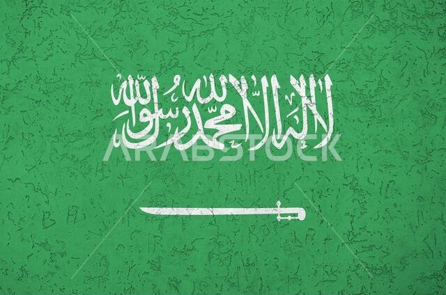 Saudi Arabia flag depicted in bright paint colors on old relief plastering wall close up. Textured banner on rough background