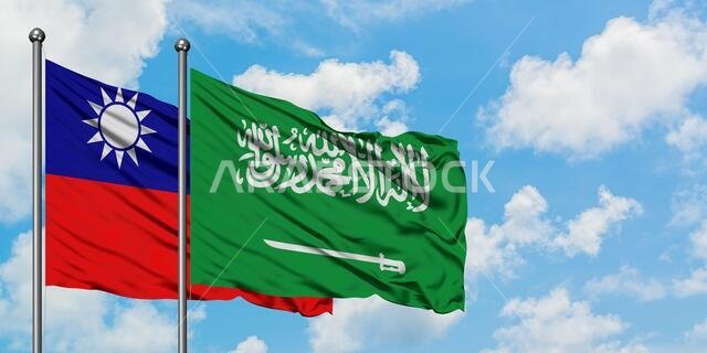 يرفرف علم تايوان وعلم المملكة العربية السعودية معاً في مهب الريح أمام سماء زرقاء صافية تتلألأ فيها الغيوم البيضاء. مفهوم الدبلوماسية، العلاقات الدولية.