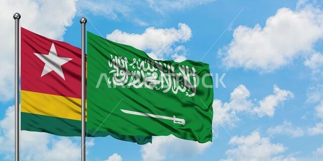Togo and Saudi Arabia flag waving in the wind against white cloudy blue sky together. Diplomacy concept, international relations.