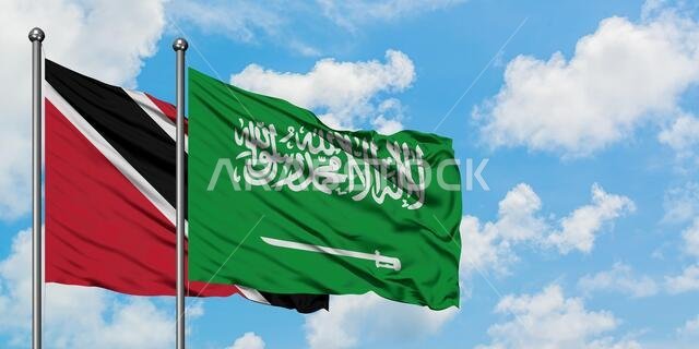 يرفرف علم ترينيداد وتوباغو وعلم المملكة العربية السعودية معاً في مهب الريح أمام سماء زرقاء ملبدة بالغيوم البيضاء. مفهوم الدبلوماسية، العلاقات الدولية.