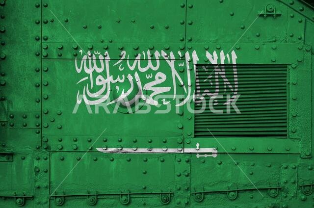 علم المملكة العربية السعودية مُصوَّر على جانب دبابة عسكرية مدرعة (صورة مقرّبة). خلفية مفاهيمية للقوات المسلحة. علم المملكة العربية السعودية مُصوَّر على جانب دبابة عسكرية مدرعة (صورة مقرّبة). خلفية مفاهيمية للقوات المسلحة.