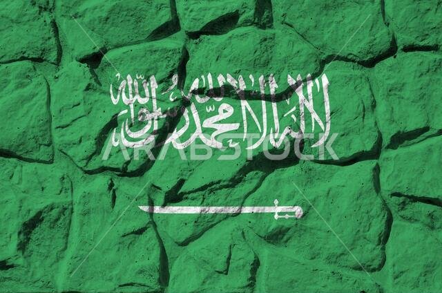 Saudi Arabia flag depicted in paint colors on old stone wall close up. Textured banner on rock wall background
