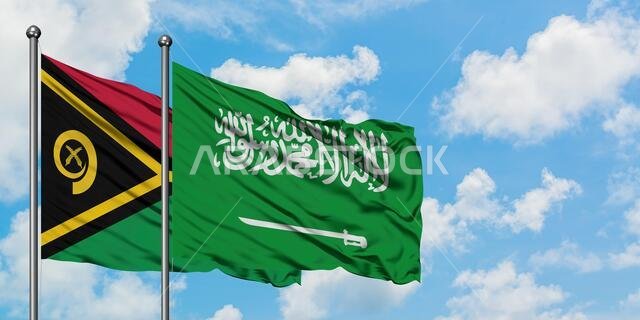 يرفرف علم فانواتو وعلم المملكة العربية السعودية معاً في مهب الريح أمام سماء زرقاء صافية تتلألأ فيها الغيوم البيضاء. مفهوم الدبلوماسية، العلاقات الدولية.