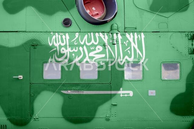 علم المملكة العربية السعودية مُصوَّر على جانب مروحية عسكرية مدرعة (صورة مقرّبة). خلفية مفاهيمية لطائرات القوات المسلحة.