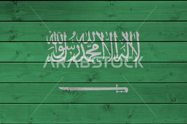 Saudi Arabia flag depicted in bright paint colors on old wooden wall close up. Textured banner on rough background