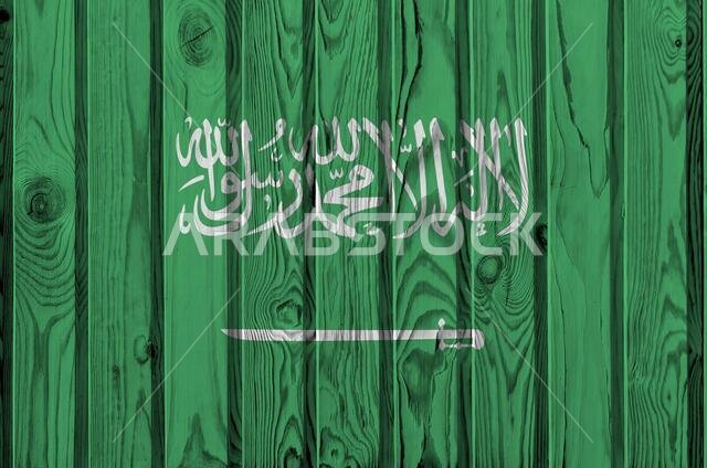 Saudi Arabia flag depicted in bright paint colors on old wooden wall close up. Textured banner on rough background
