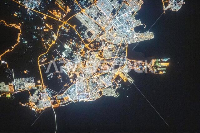 A nighttime view of Dammam, Saudi Arabia as seem from the International Space Station orbiting 262 miles above the port city December 3, 2019 in Earth Orbit. The fork-like structure at right is the King Abdulaziz Seaport.