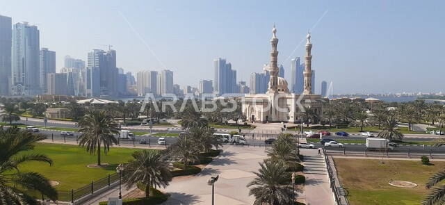 صورة لكورنيش الشارقة في دولة الإمارات العربية المتحدة ، بحيرة خالد في الشارقة واجهة المجاز ، الأبراج وناطحات السحاب ، معالم سياحية ترفيهية في الشارقة ، معالم الإمارات السياحية ، حركة سير السيارات على الطريق العام  ، مسجد النور في الشارقة