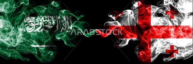 المملكة العربية السعودية ضد جورجيا، أعلام جورجية ضبابية غامضة موضوعة جنبًا إلى جنب. أعلام دخانية حريرية سميكة الألوان من العربية والجورجية.