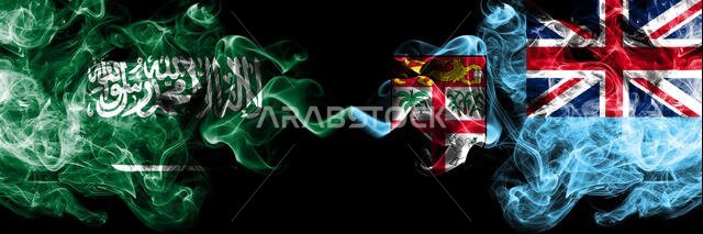 Saudi Arabia Kingdom vs Fiji smoky mystic flags placed side by side. Thick colored silky smoke flags of Arabic, Arabian and Fiji