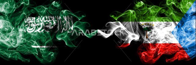أعلام المملكة العربية السعودية وغينيا الاستوائية، معروضة جنباً إلى جنب، بألوان دخانية ساحرة. أعلام دخانية سميكة ملونة حريرية تمثل أعلاماً عربية وإسبانية وغينية استوائية.