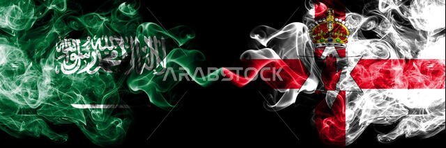 أعلام المملكة العربية السعودية وأعلام أيرلندا الشمالية الدخانية الغامضة موضوعة جنبًا إلى جنب. أعلام دخانية سميكة ملونة حريرية تمثل الدول العربية والأيرلندية الشمالية
