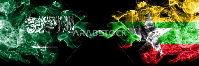 Saudi Arabia Kingdom vs Myanmar smoky mystic flags placed side by side. Thick colored silky smoke flags of Arabic, Arabian and Myanmar
