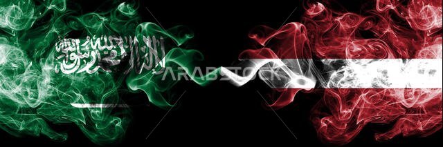 المملكة العربية السعودية ضد لاتفيا، أعلام لاتفيا الدخانية الغامضة موضوعة جنبًا إلى جنب. أعلام دخانية حريرية سميكة الألوان من اللغة العربية واللاتفية.