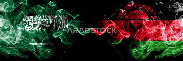 المملكة العربية السعودية ضد مالاوي، أعلام مالاوي الدخانية الغامضة موضوعة جنبًا إلى جنب. أعلام دخانية حريرية ملونة سميكة من العربية والمالاوية.