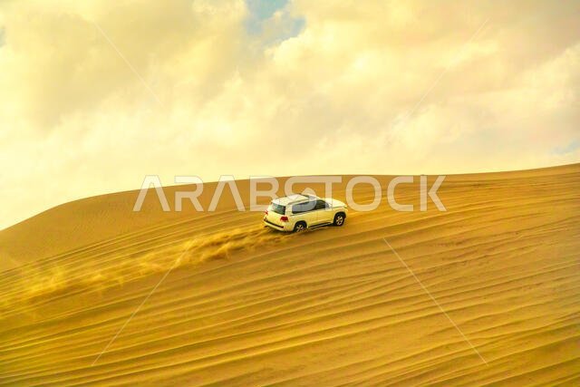 خور العديد، قطر - 19 فبراير 2019: مغامرة على الطرق الوعرة بسيارة تويوتا لاند كروزر في الصحراء العربية. اجتياز الكثبان الرملية بسيارة دفع رباعي، والاقتراب من البحر الداخلي
