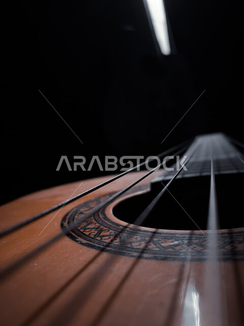 صورة مقربة لجيتار كلاسيكي في الظلام , آلة موسيقية وترية  , عزف الموسيقى 