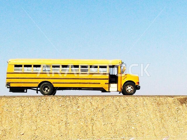 typical yellow school bus for transfer of labor personnel in the desert of saudi arabia