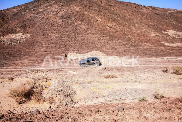صورة جوية لسيارة دفع رباعي وحيدة عند مدخل فوهة بركان حرة كشب، منطقة مكة المكرمة، المملكة العربية السعودية