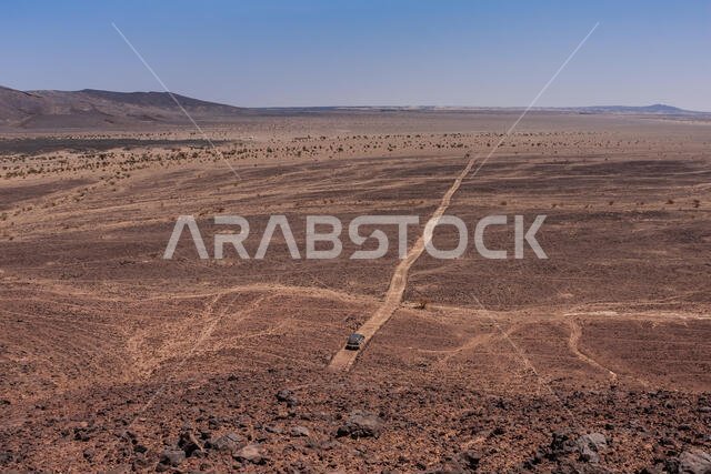 صورة جوية لسيارة دفع رباعي وحيدة في حقل حرة كشب البركاني، منطقة مكة المكرمة، المملكة العربية السعودية