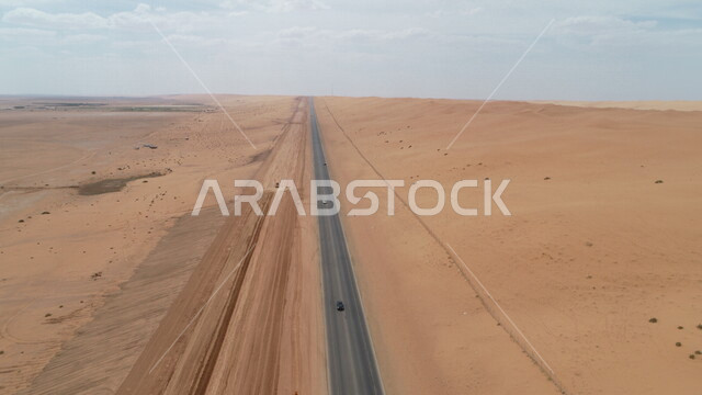صورة لخط السير السريع وسط الصحراء ، طريق صحراوي ، طريق اسفلتي سريع بين الكثبان الرملية ، الطبيعة الصحراوية ، الكثبان الرملية ، مناطق صحراوية سياحية ، طريق سفر صحراوي