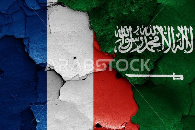 أعلام فرنسا والمملكة العربية السعودية مرسومة على جدار متصدع