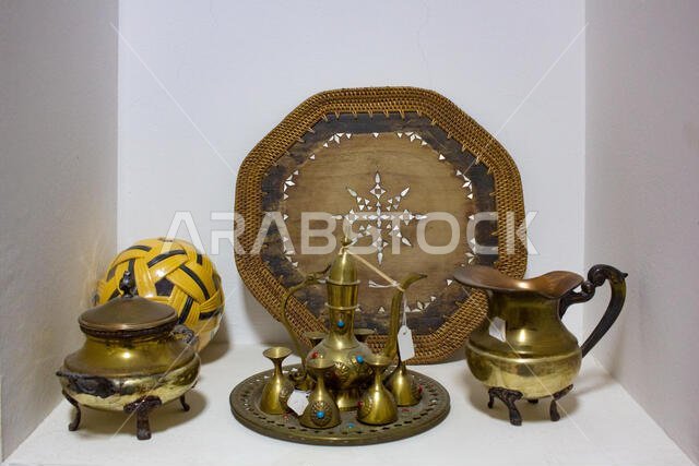 قطع أثرية عربية تقليدية قديمة. إبريق قهوة نحاسي، أكواب، أطباق وصواني.