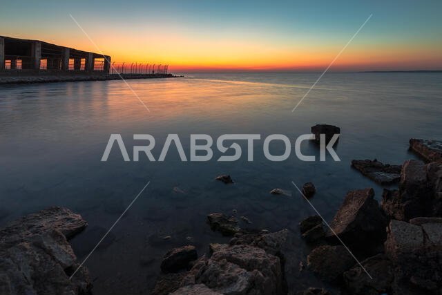 Dramatic sunrise with silky water view in Al uqair ruined fort sea side Saudi Arabia.