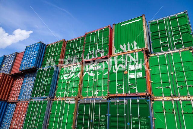The national flag of Saudi Arabia  on a large number of metal containers for storing goods stacked in rows on top of each other. Conception of storage