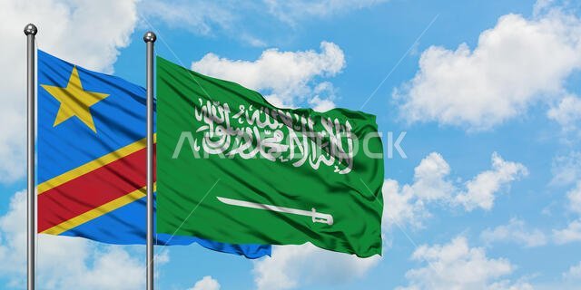 يرفرف علم الكونغو وعلم المملكة العربية السعودية معاً في مهب الريح أمام سماء زرقاء صافية تتخللها غيوم بيضاء. مفهوم الدبلوماسية، العلاقات الدولية.