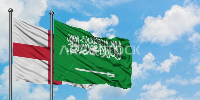 يرفرف علم إنجلترا والسعودية معاً في مهب الريح أمام سماء زرقاء صافية تتلألأ بالغيوم البيضاء. مفهوم الدبلوماسية، العلاقات الدولية. يرفرف علم إنجلترا والسعودية معاً في مهب الريح أمام سماء زرقاء صافية تتلألأ بالغيوم البيضاء. مفهوم الدبلوماسية، العلاقات الدولية.