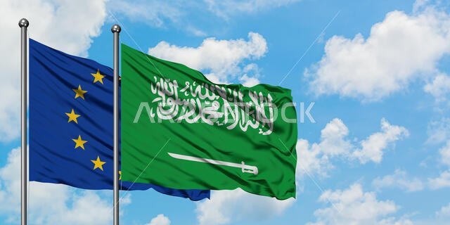 European Union and Saudi Arabia flag waving in the wind against white cloudy blue sky together. Diplomacy concept, international relations.