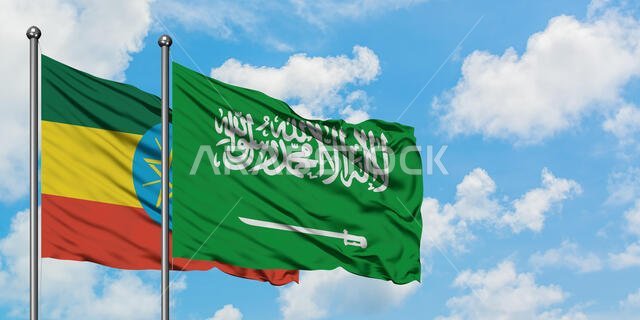 يرفرف علم إثيوبيا وعلم السعودية معاً في مهب الريح أمام سماء زرقاء صافية تتلألأ بالغيوم البيضاء. مفهوم الدبلوماسية، العلاقات الدولية.