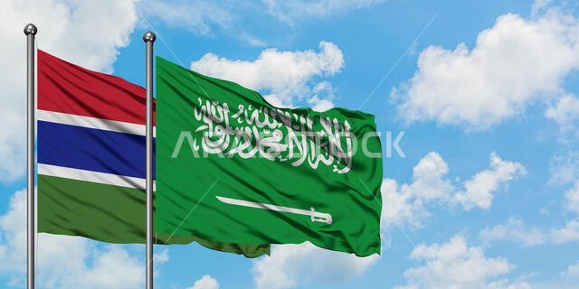 Gambia and Saudi Arabia flag waving in the wind against white cloudy blue sky together. Diplomacy concept, international relations.
